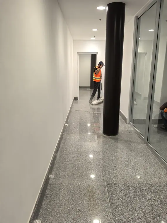 Pasillo de oficinas terminado, con piso pulido y cancelería de piso a techo.